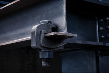 Heavy duty BeamClamp® mechanical clamp gripping wide flange structural steel I-beam flange under high tensile load without welding or drilling
